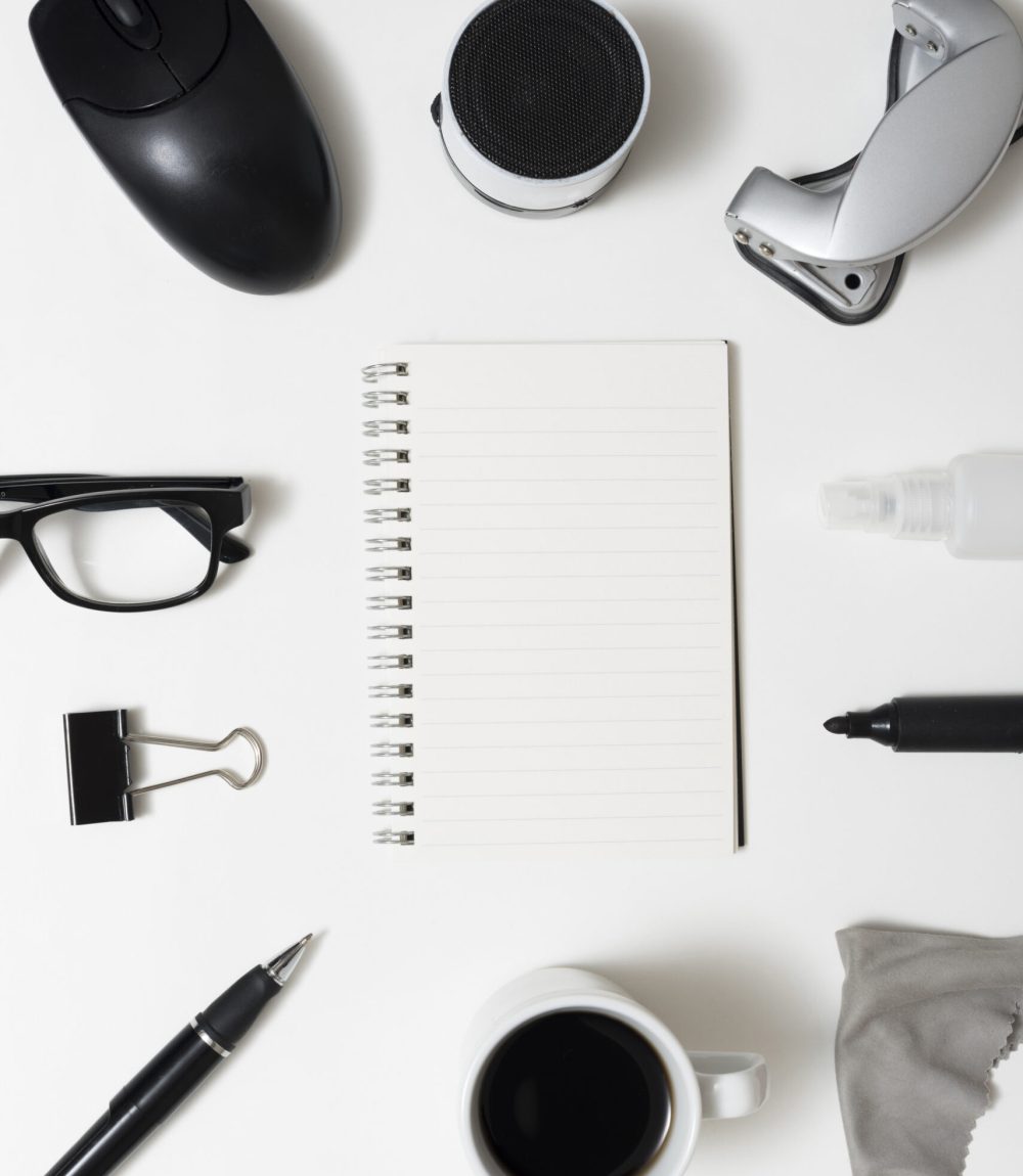 top-view-blank-spiral-notepad-with-office-stationery-coffee-cup-eyeglass-white-desk
